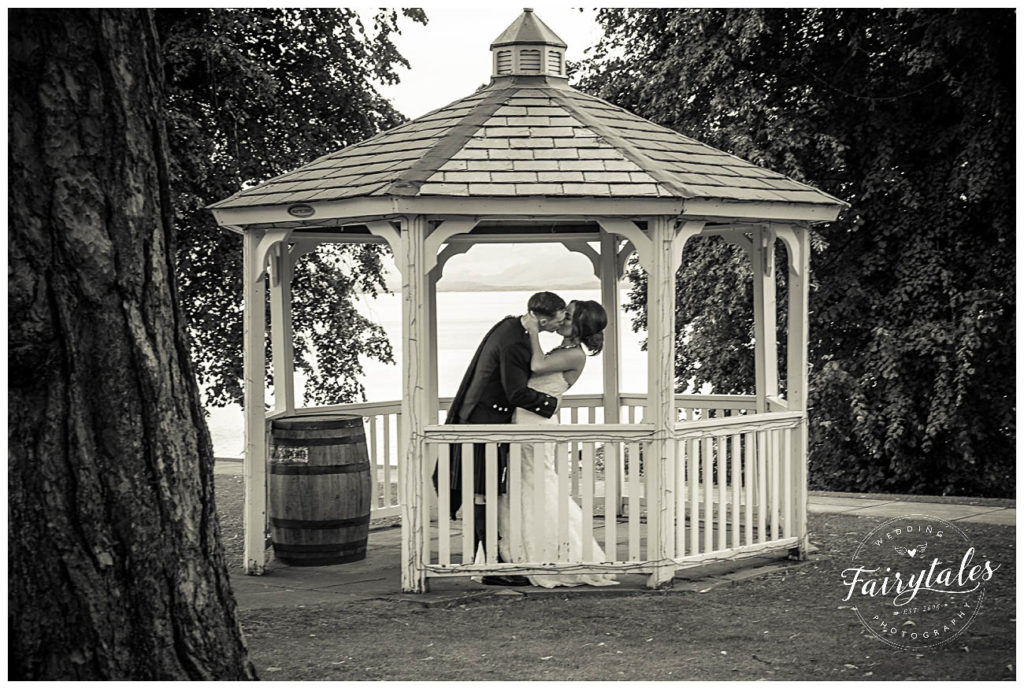groom bride and groom kissing under the gazebo at Cruin hotel