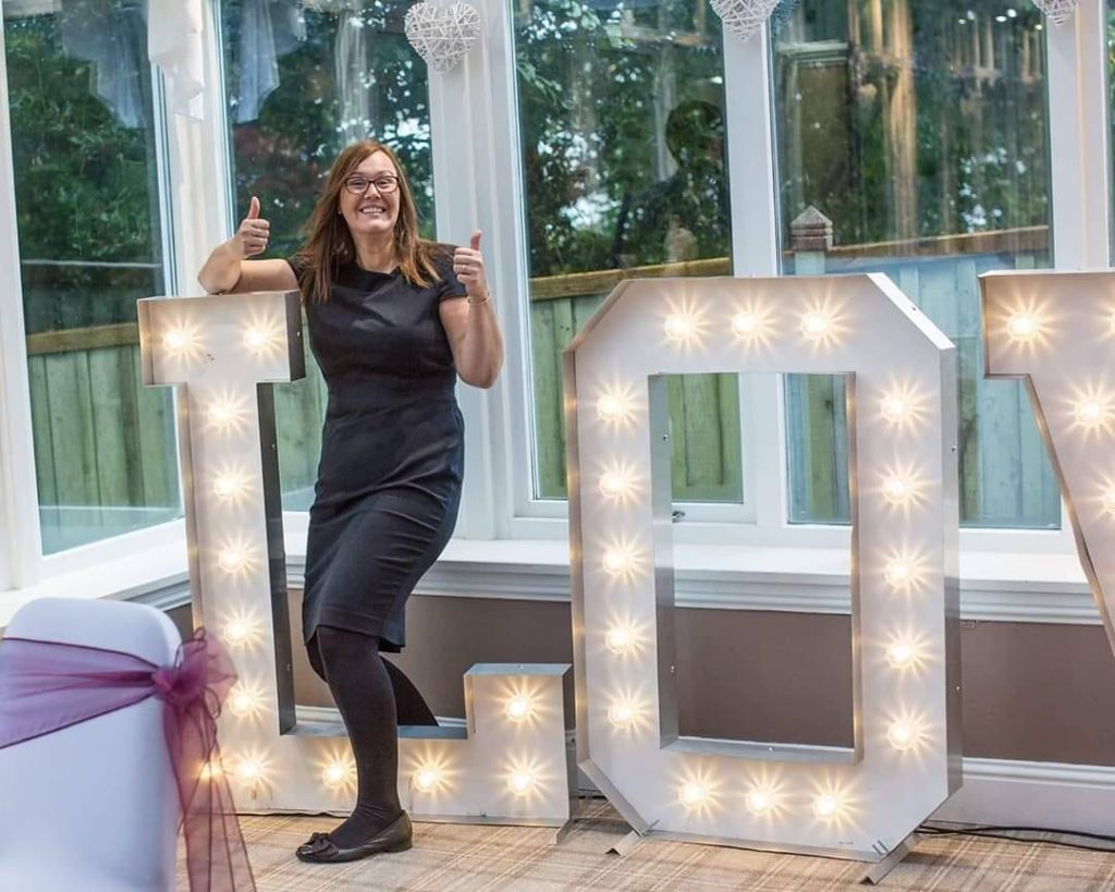 rosslea hall General manager lynn thumbs up next to love sign in conservatory