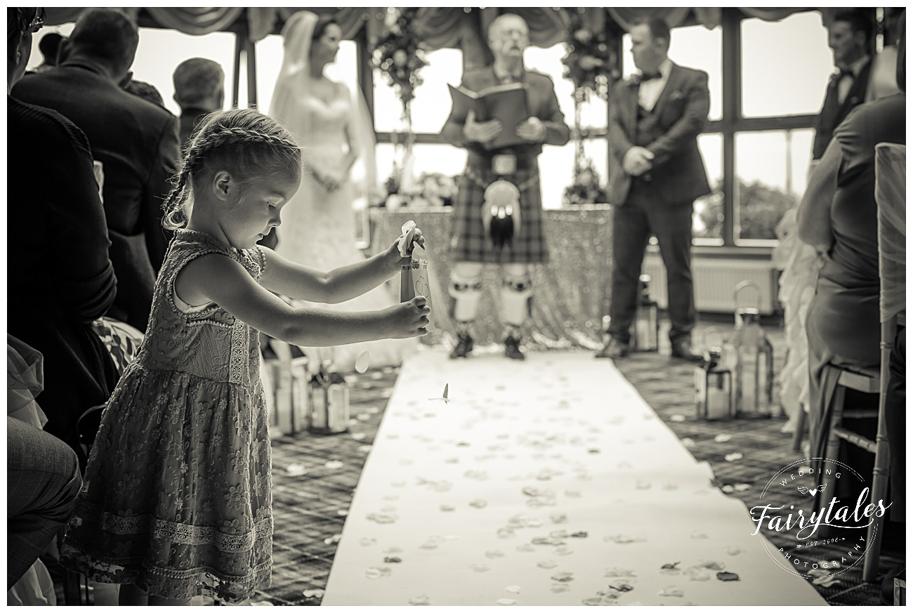 Young guest dropping flowers onto the floor at service on the wedding