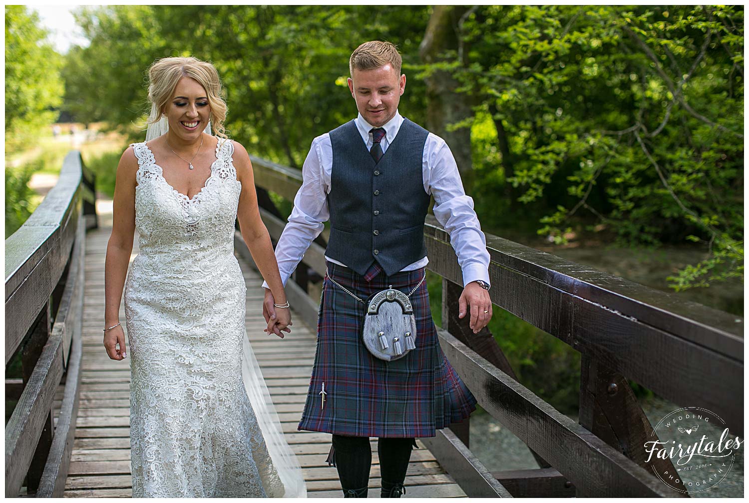 Bride and groom walking on wooden bridge in luss