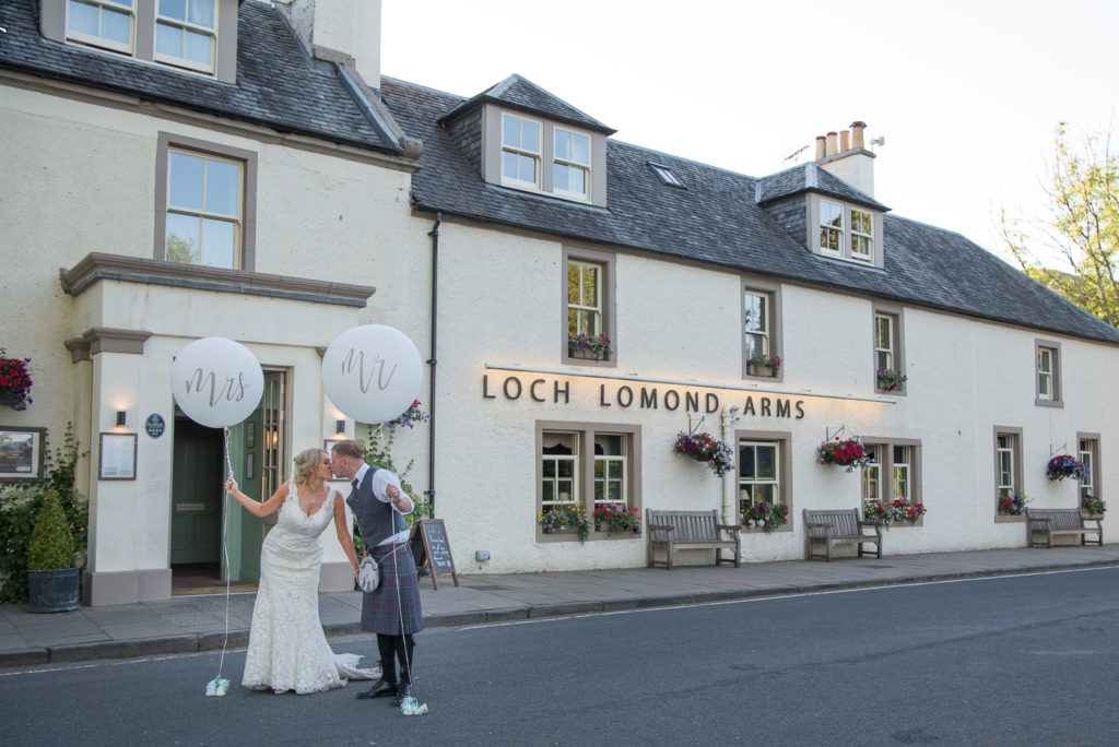 Bride and groom outside the Loch Lomond Arms hotel  with there Mr and Mrs balloons