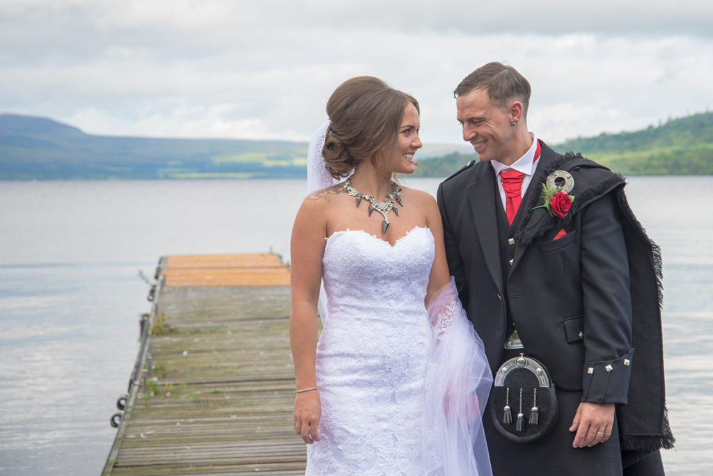 Bride and groom looking into each others eyes on the cruin lochlomond peir